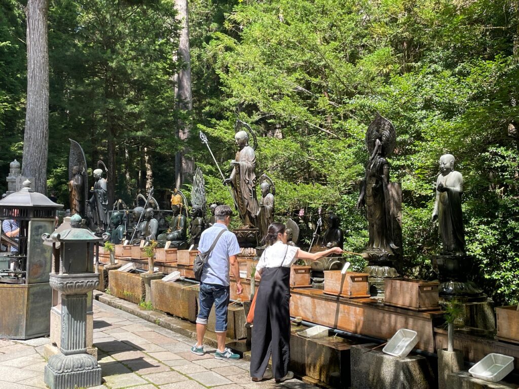 Sprinkling water on statues at Okunoin Wakayama Japan
