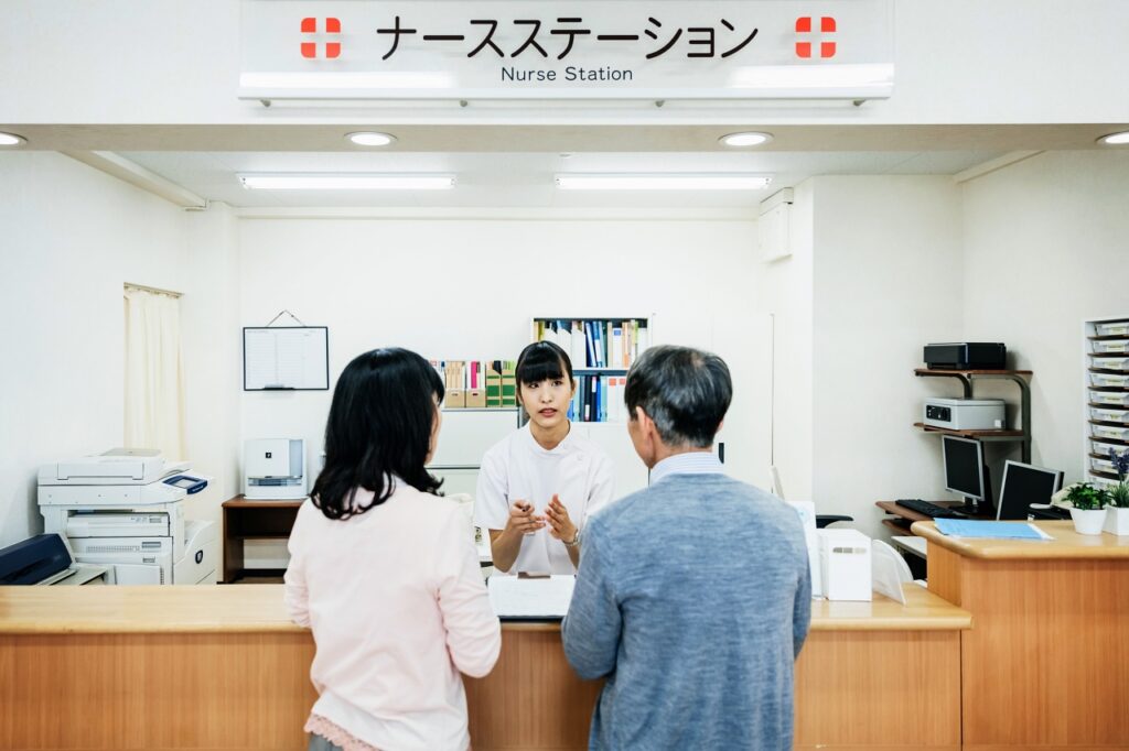 Nurse talking to couple at the hospital nurse station.
